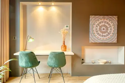 two green chairs in a bedroom with a bed at Spacious & Luminous Gem in Historic Ghent Building in Ghent