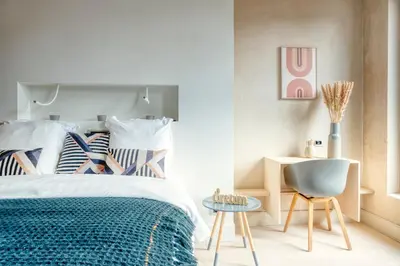 a bedroom with a bed and a chair and a table at Light-Filled Haven in Ghent in Ghent
