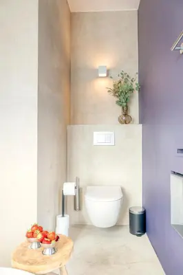 a bathroom with a toilet and a bowl of fruit on a table at Light-Filled Haven in Ghent in Ghent