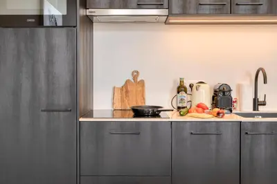 a kitchen with gray cabinets and a counter top with fruits at Light-Filled Haven in Ghent in Ghent