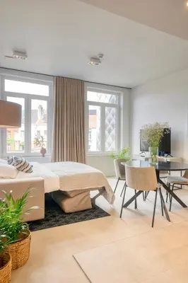 a bedroom with a bed and a table and chairs at Light-Filled Haven in Ghent in Ghent