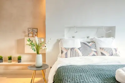 a bedroom with a bed with a vase on a table at Light-Filled Haven in Ghent in Ghent