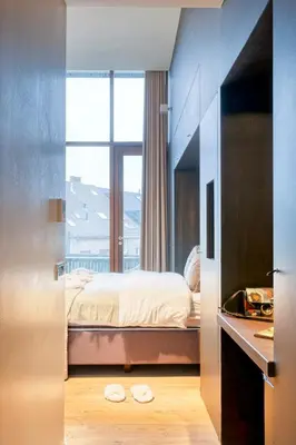 a bedroom with a bed and a large window at Ideal terraced Studio Retreat in Ghent's Center in Ghent