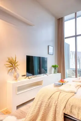 a white bedroom with a tv and a bed at Ideal terraced Studio Retreat in Ghent's Center in Ghent