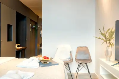 a bedroom with two chairs and a table with fruit on a bed at Ideal terraced Studio Retreat in Ghent's Center in Ghent