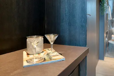 two wine glasses sitting on a table with money at Ideal terraced Studio Retreat in Ghent's Center in Ghent
