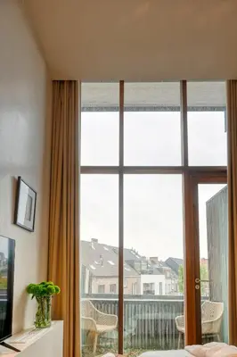 a bedroom with a large window with a view at Ideal terraced Studio Retreat in Ghent's Center in Ghent