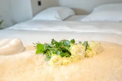 a bouquet of white roses on a bed at Charming Attic Retreat in Historic Ghent Center in Ghent