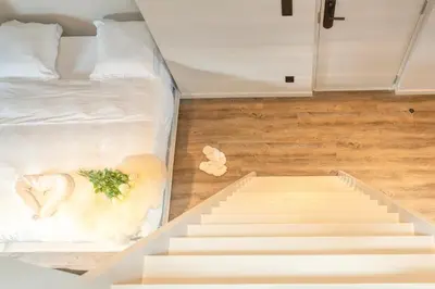 a room with stairs leading up to a bed at Charming Attic Retreat in Historic Ghent Center in Ghent