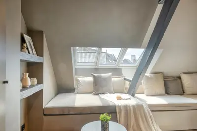 a small room with a bed and a window at Charming Attic Retreat in Historic Ghent Center in Ghent