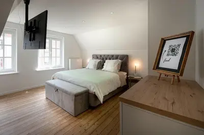 a bedroom with a bed and a table with a picture at 8z dreamz in Ghent