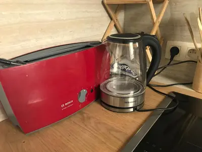 a red blender sitting on a counter next to a toaster at Appartement lumineux - Bruxelles in Brussels
