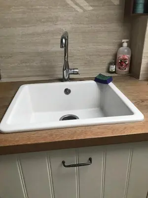 a white sink with a faucet in a kitchen at Appartement lumineux - Bruxelles in Brussels