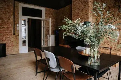 a dining room table with chairs and a vase of flowers at Boutique app in Antwerp Centre in Antwerp
