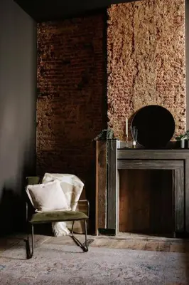a chair sitting in a room with a fireplace at Boutique app in Antwerp Centre in Antwerp