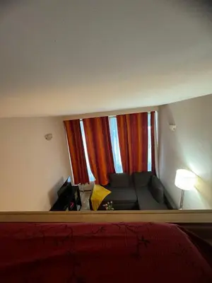 a living room with a couch and a large window at B&B appartement in Brussels