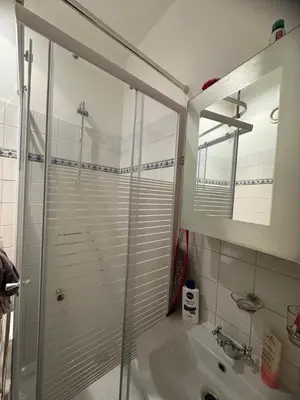 a bathroom with a glass shower and a sink at B&B appartement in Brussels