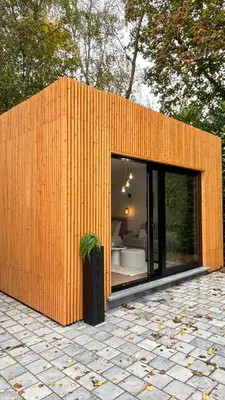 a small wooden building with a bedroom in it at MY Cabane -POOL HOUSE avec Sauna privée près de Bruxelles in Oppem