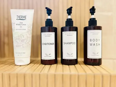 a group of four bottles of soap on a wooden shelf at MY Cabane -POOL HOUSE avec Sauna privée près de Bruxelles in Oppem