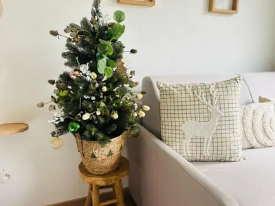 a christmas tree in a pot on a stool next to a couch at MY Cabane -POOL HOUSE avec Sauna privée près de Bruxelles in Oppem