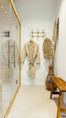 a dressing room with a coat on a rack and a table at MY Cabane -POOL HOUSE avec Sauna privée près de Bruxelles in Oppem