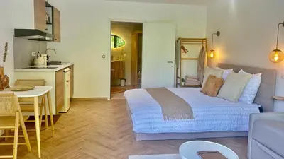 a bedroom with a large bed and a kitchen at MY Cabane -POOL HOUSE avec Sauna privée près de Bruxelles in Oppem