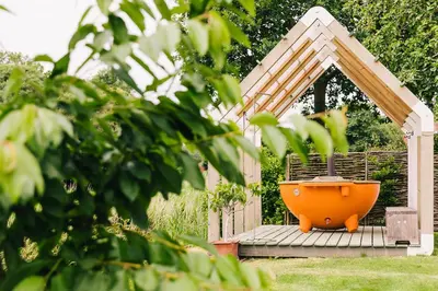 an orange bird bath in a gazebo at Logieslogees in Tielrode