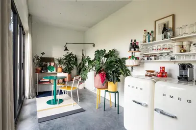 a kitchen with a table and chairs and a refrigerator at Logieslogees in Tielrode