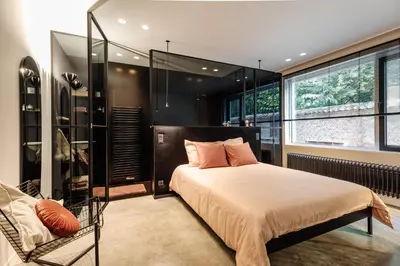 a bedroom with a bed and a large window at Logieslogees in Tielrode