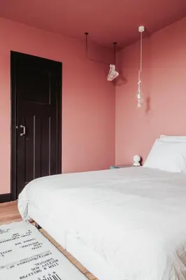 a bedroom with a white bed and a pink wall at Huis Hector Mechiels HOUSE in Lindeken