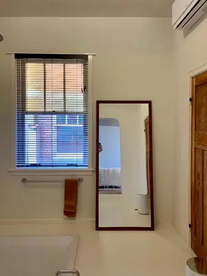 a mirror in a bathroom with a tub and a window at Huis Hector Mechiels HOUSE in Lindeken