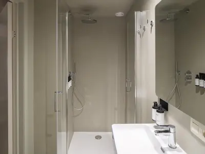a white bathroom with a shower and a sink at Lits de Lo - Boutique Rooms in Ghent