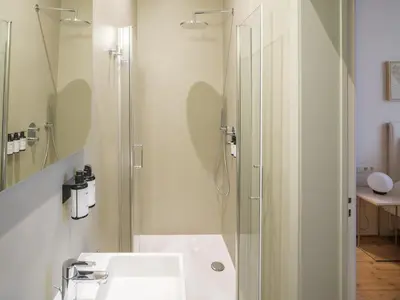 a white bathroom with a shower and a sink at Lits de Lo - Boutique Rooms in Ghent