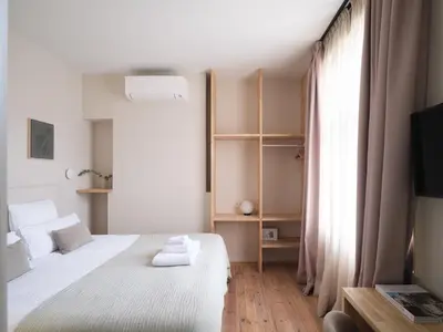 a bedroom with a bed with white sheets and a window at Lits de Lo - Boutique Rooms in Ghent