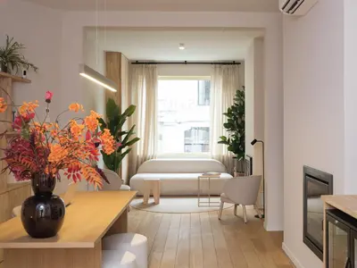 a living room with a bed and a vase of flowers at Lits de Lo - Boutique Rooms in Ghent