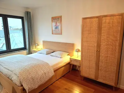 a bedroom with a bed and a large window at Studio Viktory in Antwerp