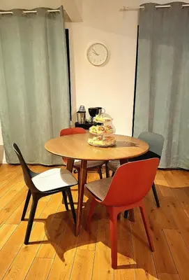 a dining room table with chairs and a clock on the wall at Studio Viktory in Antwerp