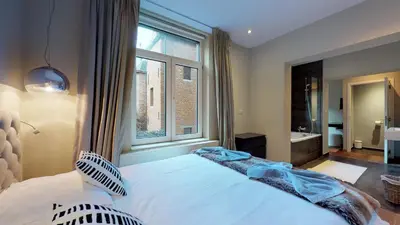 a bedroom with a large bed and a window at Villa Sablon in Brussels