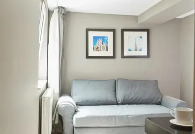 a living room with a couch and two pictures on the wall at Villa Sablon in Brussels