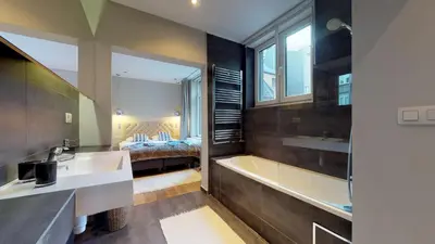 a bathroom with a sink and a tub and a bed at Villa Sablon in Brussels
