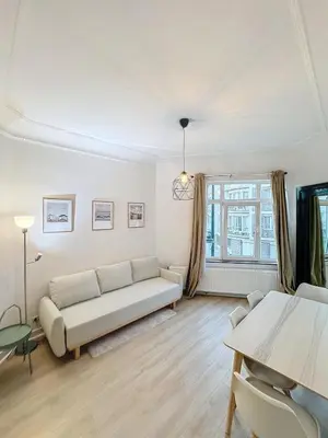 a living room with a couch and a table at Magnifique appartement une chambre in Brussels