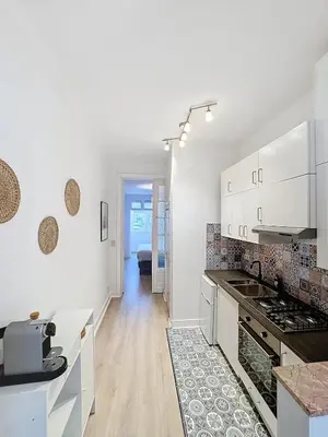 a kitchen with white cabinets and a counter top at Magnifique appartement une chambre in Brussels