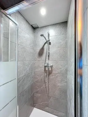 a shower with a glass door in a bathroom at Magnifique appartement une chambre in Brussels