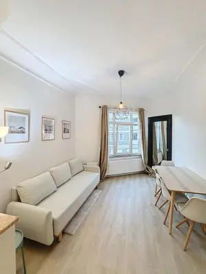 a living room with a couch and a table at Magnifique appartement une chambre in Brussels
