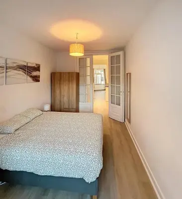 a bedroom with a bed and a hallway at Magnifique appartement une chambre in Brussels