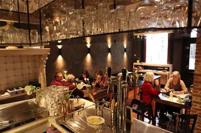 a group of people sitting at tables in a restaurant at B&B Sablon Antwerp in Antwerp