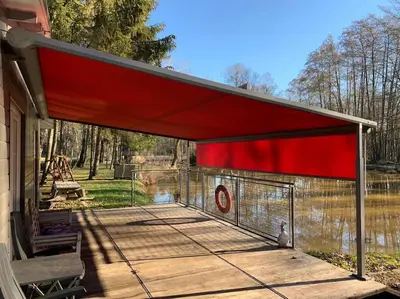 a chicken coop with a red roof on a patio at Unieke chalet aan het water in Lille