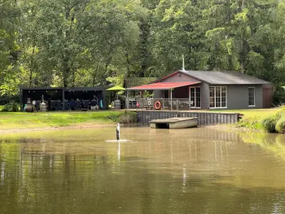 a house in the middle of a body of water at Unieke chalet aan het water in Lille