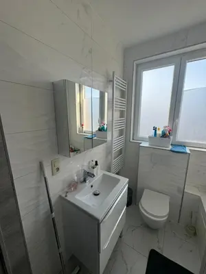 a white bathroom with a sink and a toilet at Simpleroom in Brussels