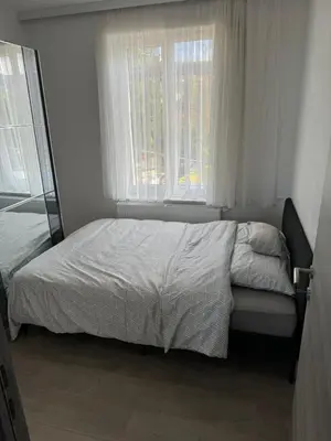 a bed in a bedroom with two windows at Simpleroom in Brussels